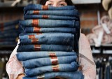 Woman Holding Pile of Jeans