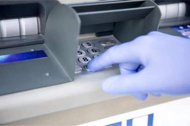 ATM with gloved hand