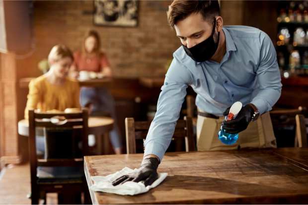 waiter in mask cleaning table