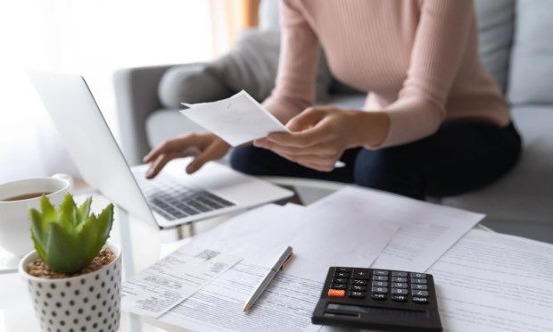 woman paying bills, using calculator