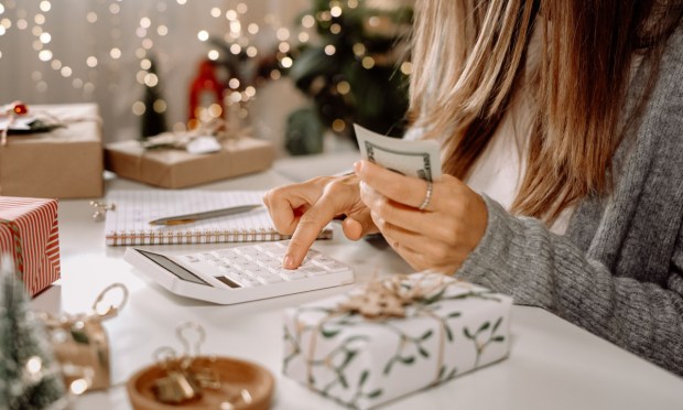 woman with calculator and holiday gifts