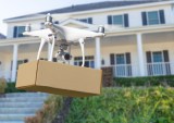 drone delivering package in front of house