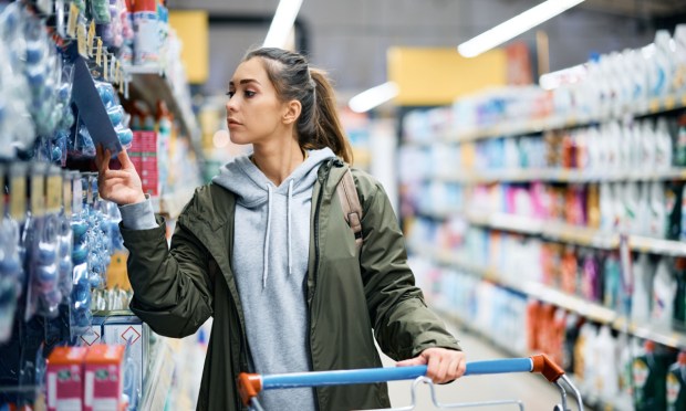woman checking grocery prices in store