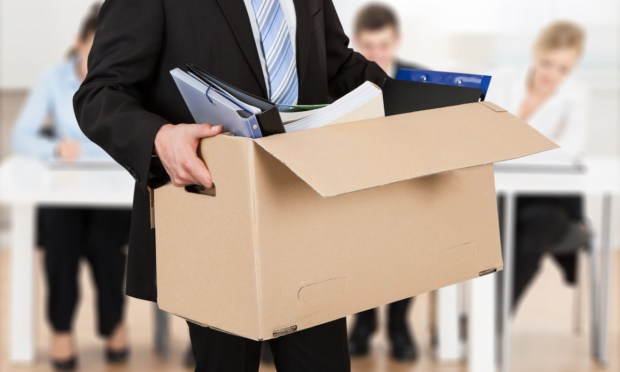 laid-off businessman carrying box from office