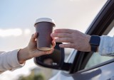 coffee cup being handed to driver