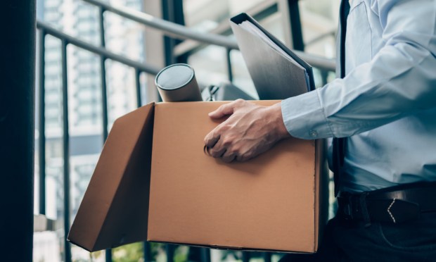 unemployed person carrying box from office