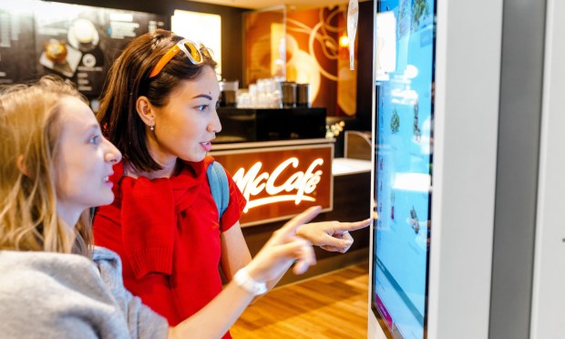 two people using fast food self-service kiosk