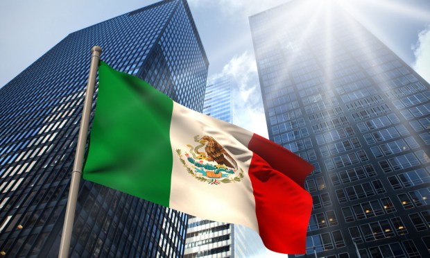 Mexican flag against tall buildings