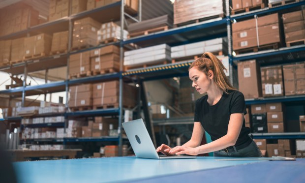 woman in warehouse with laptop