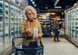 woman checking price in grocery store