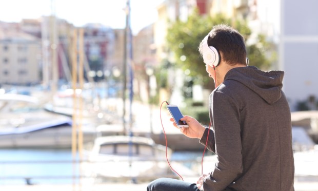 young man streaming audio on smartphone
