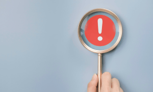 magnifying glass with exclamation point