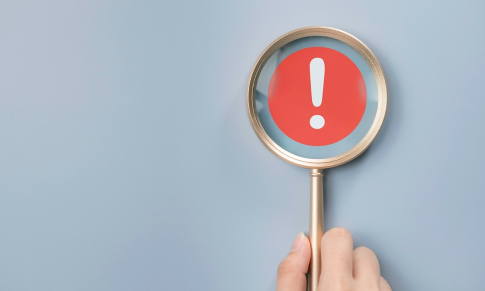 magnifying glass with exclamation point