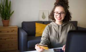 young woman with credit card at laptop