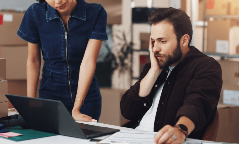 worried businessman with laptop in warehouse