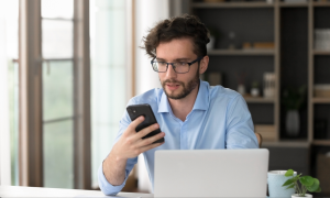 man with laptop and phone