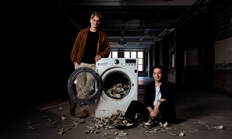 two men with cash and laundry machine