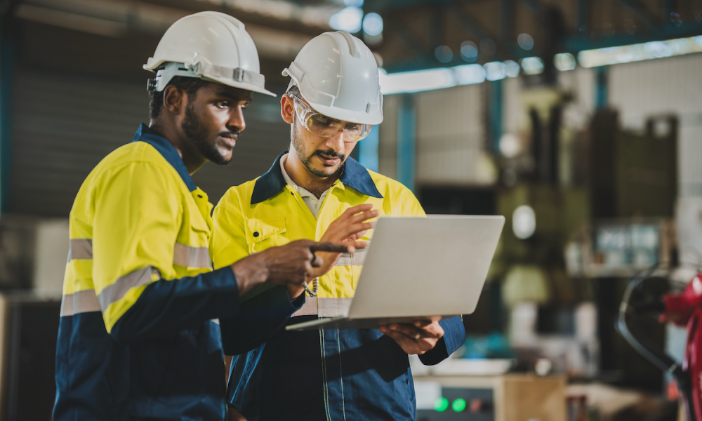 Two industrial workers with laptop