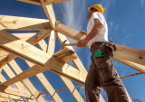builder atop house frame