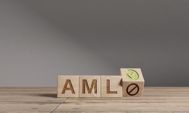 Wood cubes with acronym 'AML' - 'Anti Money Laundering' on a wooden table