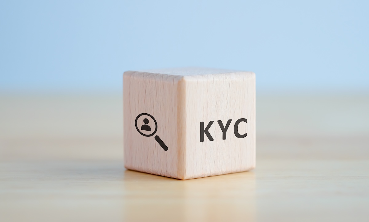KYC on wooden cubes. know your customer with magnifying glass. Business verifying the identity of its clients concept