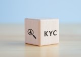 KYC on wooden cubes. know your customer with magnifying glass. Business verifying the identity of its clients concept