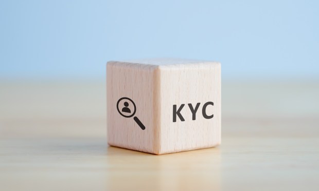 KYC on wooden cubes. know your customer with magnifying glass. Business verifying the identity of its clients concept